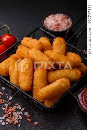 Mozzarella cheese sticks, breaded and fried with salt and tomato sauce, for takeaway. Cheese sticks Mozzarella cheese sticks, breaded and fried with salt and tomato sauce, for takeaway. Cheese sticks 140747582