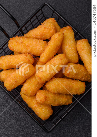 Mozzarella cheese sticks, breaded and fried with salt and tomato sauce, for takeaway. Cheese sticks Mozzarella cheese sticks, breaded and fried with salt and tomato sauce, for takeaway. Cheese sticks 140747584