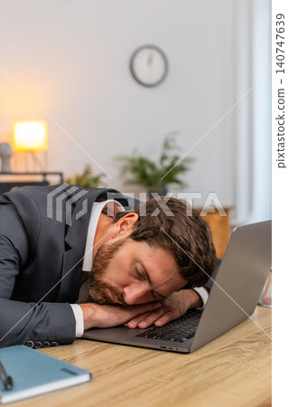 Middle-aged businessman exhausted types report falls asleep on laptop keyboard face down during work Middle-aged businessman exhausted types report falls asleep on laptop keyboard face down during work 140747639