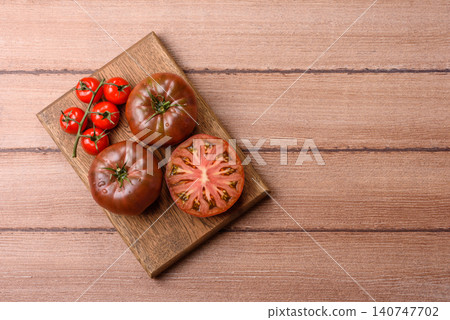 Fresh pink and black tomatoes adora or kumato as an ingredient for a salad. Tomatoes adora or kumato Fresh pink and black tomatoes adora or kumato as an ingredient for a salad. Tomatoes adora or kumato 140747702