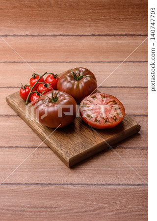 Fresh pink and black tomatoes adora or kumato as an ingredient for a salad. Tomatoes adora or kumato Fresh pink and black tomatoes adora or kumato as an ingredient for a salad. Tomatoes adora or kumato 140747703