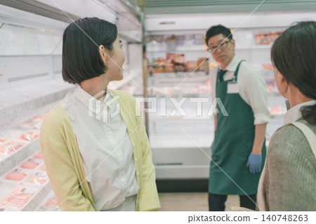 A housewife stops a supermarket employee. A housewife stops a supermarket employee. 140748263
