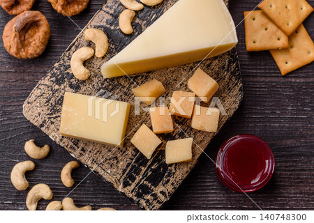 Aged cheese in a triangular block with jam, figs, and nuts. Aged cheese 140748300