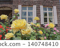A garden of a Western-style mansion with yellow roses in bloom and a classical stone building. 140748410