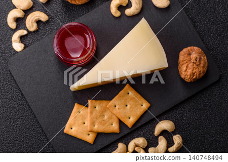 Aged cheese in a triangular block with jam, figs, and nuts. Aged cheese Aged cheese in a triangular block with jam, figs, and nuts. Aged cheese 140748494