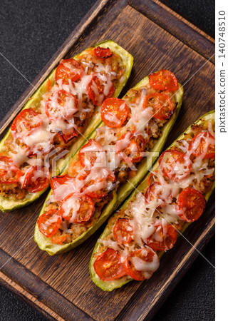 Baked zucchini half with minced meat, tomatoes, cheese, salt, and spices. Zucchini with minced meat 140748510