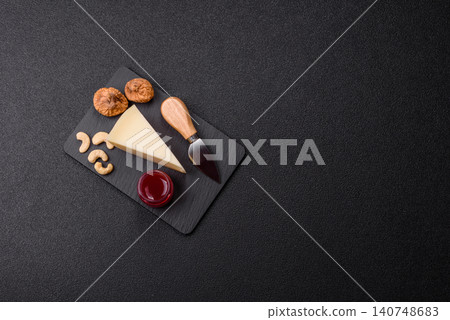 Aged cheese in a triangular block with jam, figs, and nuts. Aged cheese Aged cheese in a triangular block with jam, figs, and nuts. Aged cheese 140748683