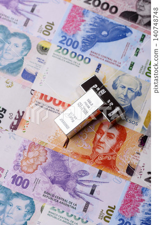 A silver bar, white metal against a backdrop of Argentine money, as a concept for the sales market 140748748