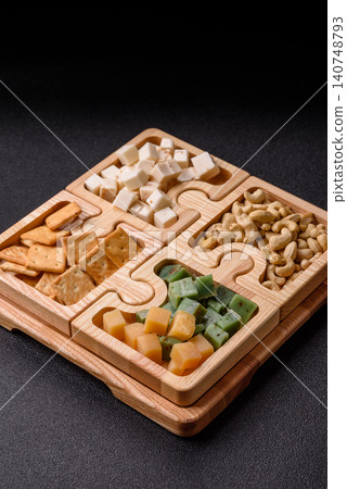 A tray with cubes of mozzarella, and Parmesan cheese, nuts, and crackers. Cheese, crackers, and nuts A tray with cubes of mozzarella, and Parmesan cheese, nuts, and crackers. Cheese, crackers, and nuts 140748793