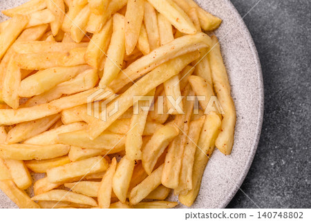Golden French fries fried with salt and spices, unhealthy takeaway food. French fries Golden French fries fried with salt and spices, unhealthy takeaway food. French fries 140748802