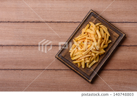 Golden French fries fried with salt and spices, unhealthy takeaway food. French fries Golden French fries fried with salt and spices, unhealthy takeaway food. French fries 140748803