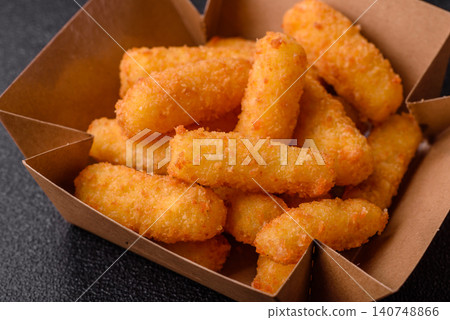 Mozzarella cheese sticks, breaded and fried with salt and tomato sauce, for takeaway. Cheese sticks Mozzarella cheese sticks, breaded and fried with salt and tomato sauce, for takeaway. Cheese sticks 140748866