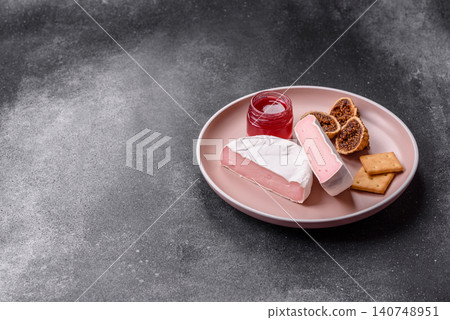 Pink Brie or Camembert cheese with honey, jam, figs, and crackers. Brie cheese Pink Brie or Camembert cheese with honey, jam, figs, and crackers. Brie cheese 140748951