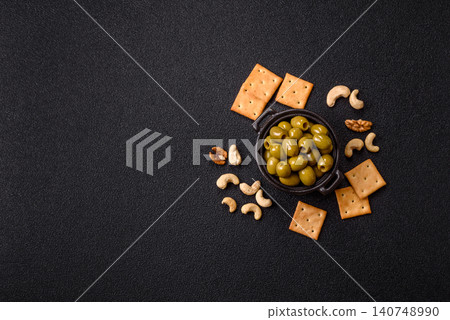 Whole green olives without pits in a bowl as an ingredient for cooking at home. Green olives Whole green olives without pits in a bowl as an ingredient for cooking at home. Green olives 140748990