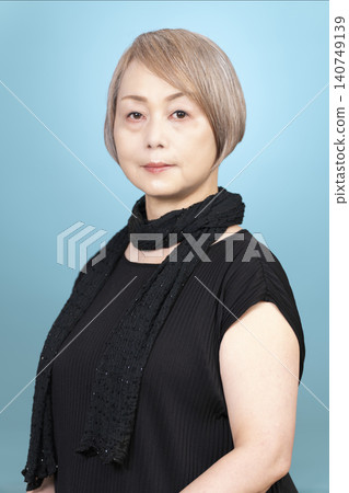 一位老年女性的肖像照，背景為淺藍色。 140749139