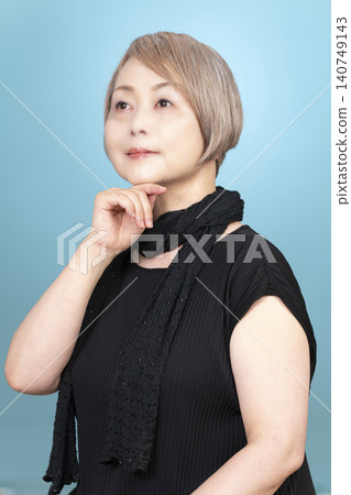 一位老年女性的肖像照，背景為淺藍色。 140749143