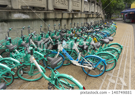Chengdu, Sichuan, China - Oct 16,2024 : A row of Qingju (Didi Bike) bikes resting at sidewalk in Chengdu, Sichuan, China on Oct 16,2024. Chengdu, Sichuan, China - Oct 16,2024 : A row of Qingju (Didi Bike) bikes resting at sidewalk in Chengdu, Sichuan, China on Oct 16,2024. 140749881