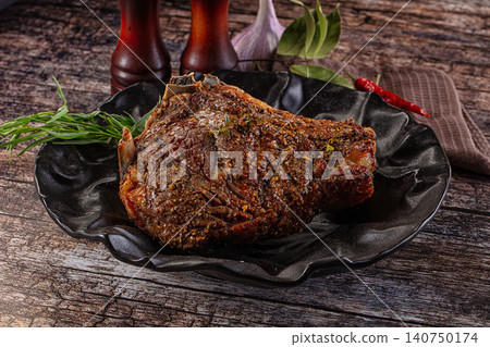 Grilled ribeye steak with herbs and spices on black plate Grilled ribeye steak with herbs and spices on black plate 140750174