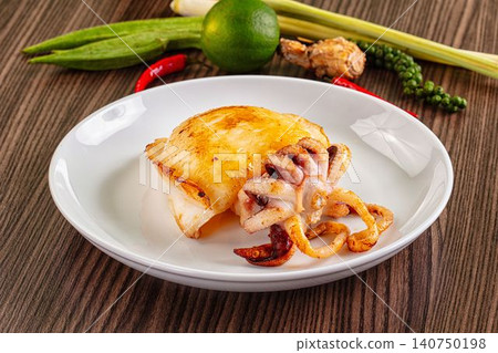 Grilled cuttlefish on white plate with lime and chili 140750198