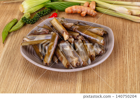 Fresh razor clams on ceramic plate with lemongrass turmeric and chili on wooden table Fresh razor clams on ceramic plate with lemongrass turmeric and chili on wooden table 140750204