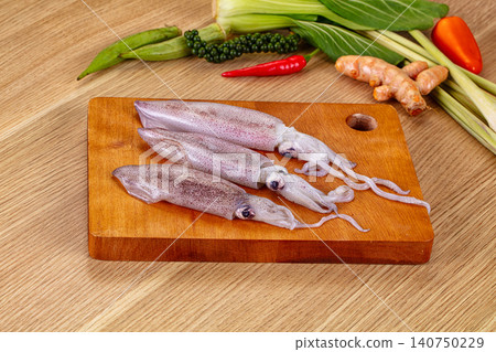 Fresh squid on wooden cutting board with Asian ingredients Fresh squid on wooden cutting board with Asian ingredients 140750229