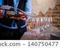 Professional waiter pouring rose sparkling wine into champagne flutes at an event 140750477