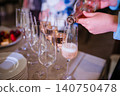Pouring rose sparkling wine or champagne into elegant crystal glasses at a celebration 140750478