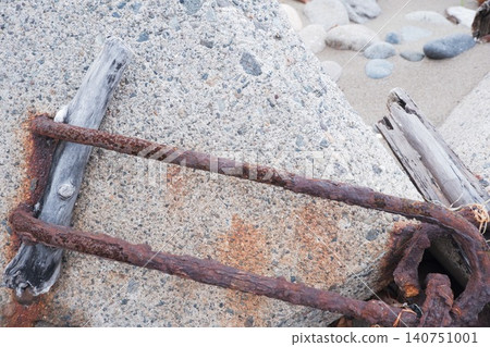 Rusty rebar and driftwood attached to concrete blocks on the coast Rusty rebar and driftwood attached to concrete blocks on the coast 140751001