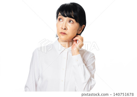 一位身穿白襯衫、表情焦慮的中年婦女。 140751678