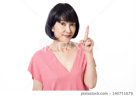 一位留著波波頭的中年婦女面帶微笑，舉起食指。 140751679