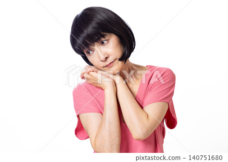 一位留著波波頭、穿著粉紅色短袖針織衫的中年婦女心事重重。 140751680