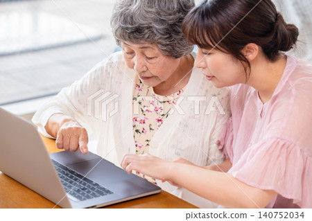 一位老婦人正在學習如何使用筆記型電腦。 140752034