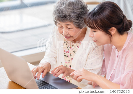 An elderly woman being taught how to use a laptop computer. An elderly woman being taught how to use a laptop computer. 140752035