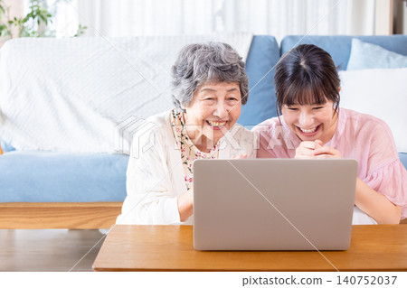 A senior woman and a young woman looking at a computer screen. A senior woman and a young woman looking at a computer screen. 140752037