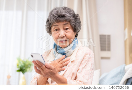 An elderly woman with her hand on her chest An elderly woman with her hand on her chest 140752066