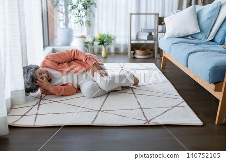 An elderly woman falls and collapses in her living room at home. An elderly woman falls and collapses in her living room at home. 140752105