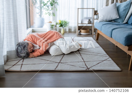 An elderly woman collapses in her living room at home. An elderly woman collapses in her living room at home. 140752106