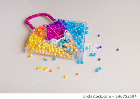 Sets of multi-colored beads and seed beads for children's arts and crafts Sets of multi-colored beads and seed beads for children's arts and crafts 140752594