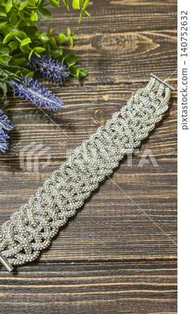 A bracelet made of shiny cords on a dark background. Women's jewelry. Handmade. A bracelet made of shiny cords on a dark background. Women's jewelry. Handmade. 140752632