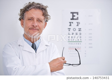 Eye, test and portrait of optometrist in clinic with glasses to check vision and exam in healthcare. Mature, doctor and reading letters on wall in medical assessment for contact lenses or eyesight Eye, test and portrait of optometrist in clinic with glasses to check vision and exam in healthcare. Mature, doctor and reading letters on wall in medical assessment for contact lenses or eyesight 140753431