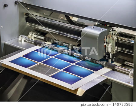 Printer prints a batch of blue business cards in a production facility during daytime hours Printer prints a batch of blue business cards in a production facility during daytime hours 140753593