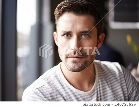 Handsome man, portrait and serious face at cafe for morning, ambition or aspiration at indoor restaurant. Attractive or young male person with beard in relax, casual clothing or style at coffee shop 140753659