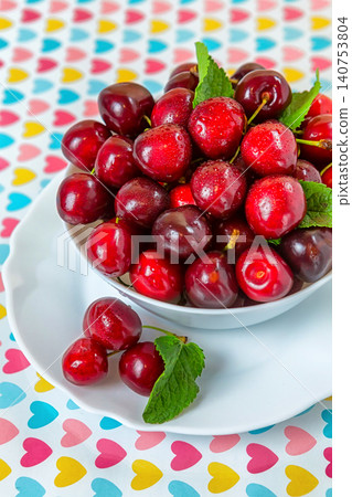 Cherries in a white plate on the table. 140753804