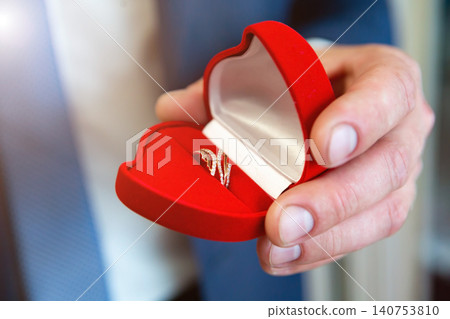 wedding rings in hand. wedding rings in the hands of the groom. wedding rings in hand. wedding rings in the hands of the groom. 140753810
