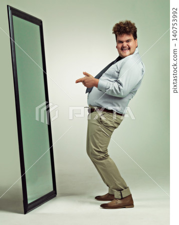 Mirror, portrait and man with happiness for pointing, excited and smile for reflection in studio. Adult, plus size and male person with comic, guy and positive to change unhealthy diet and life Mirror, portrait and man with happiness for pointing, excited and smile for reflection in studio. Adult, plus size and male person with comic, guy and positive to change unhealthy diet and life 140753992