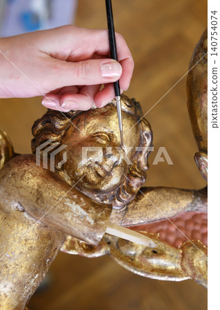 Detail Work on Ornate Wood Carving With Gold Leaf in Art Studio During Daytime 140754074