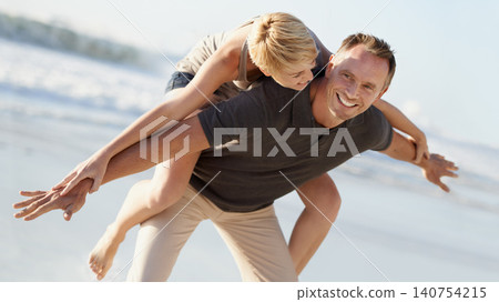 Couple, love and smile on beach with piggyback for bonding, honeymoon date and weekend holiday. Face, man and woman with embrace, happy and care in California by sea for vacation, travel or adventure Couple, love and smile on beach with piggyback for bonding, honeymoon date and weekend holiday. Face, man and woman with embrace, happy and care in California by sea for vacation, travel or adventure 140754215