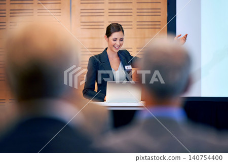 Happy woman, presentation and laptop with projector at conference in team meeting, staff training or seminar. Young female person, employee or speaker talking on podium to group for business workshop Happy woman, presentation and laptop with projector at conference in team meeting, staff training or seminar. Young female person, employee or speaker talking on podium to group for business workshop 140754400