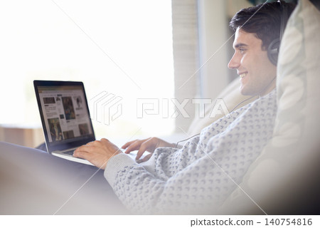 Laptop, headphones and happy man in home typing, relax or listening to sound of radio podcast on sofa. Computer, music and smile of person in lounge for internet, social media and streaming audio Laptop, headphones and happy man in home typing, relax or listening to sound of radio podcast on sofa. Computer, music and smile of person in lounge for internet, social media and streaming audio 140754816