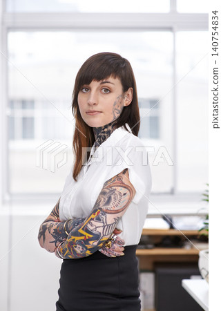 Tattoos, crossed arms and business woman in office with serious, pride and confident attitude. Grunge, professional and portrait of edgy creative designer with ink skin standing in modern workplace. Tattoos, crossed arms and business woman in office with serious, pride and confident attitude. Grunge, professional and portrait of edgy creative designer with ink skin standing in modern workplace. 140754834